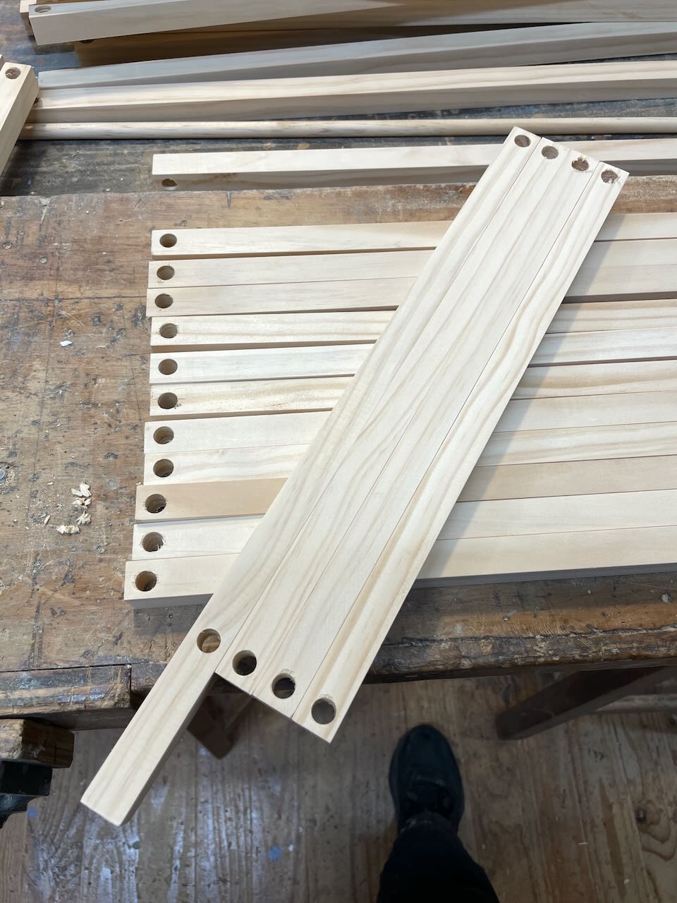 The legs of the shoe rack showing where the holes are drilled.