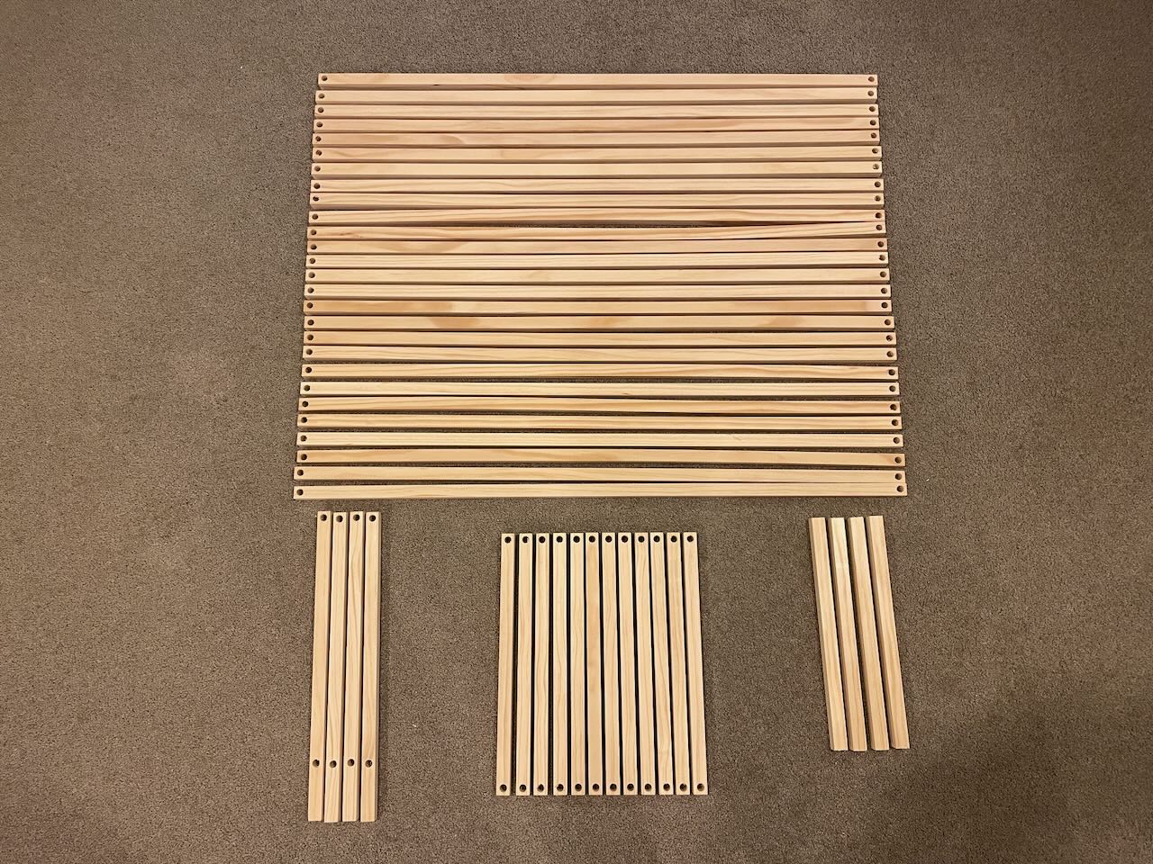 An overview of all the slats, including some support slats on the bottom right. In this picture, the legs are still missing the holes for the middle row.